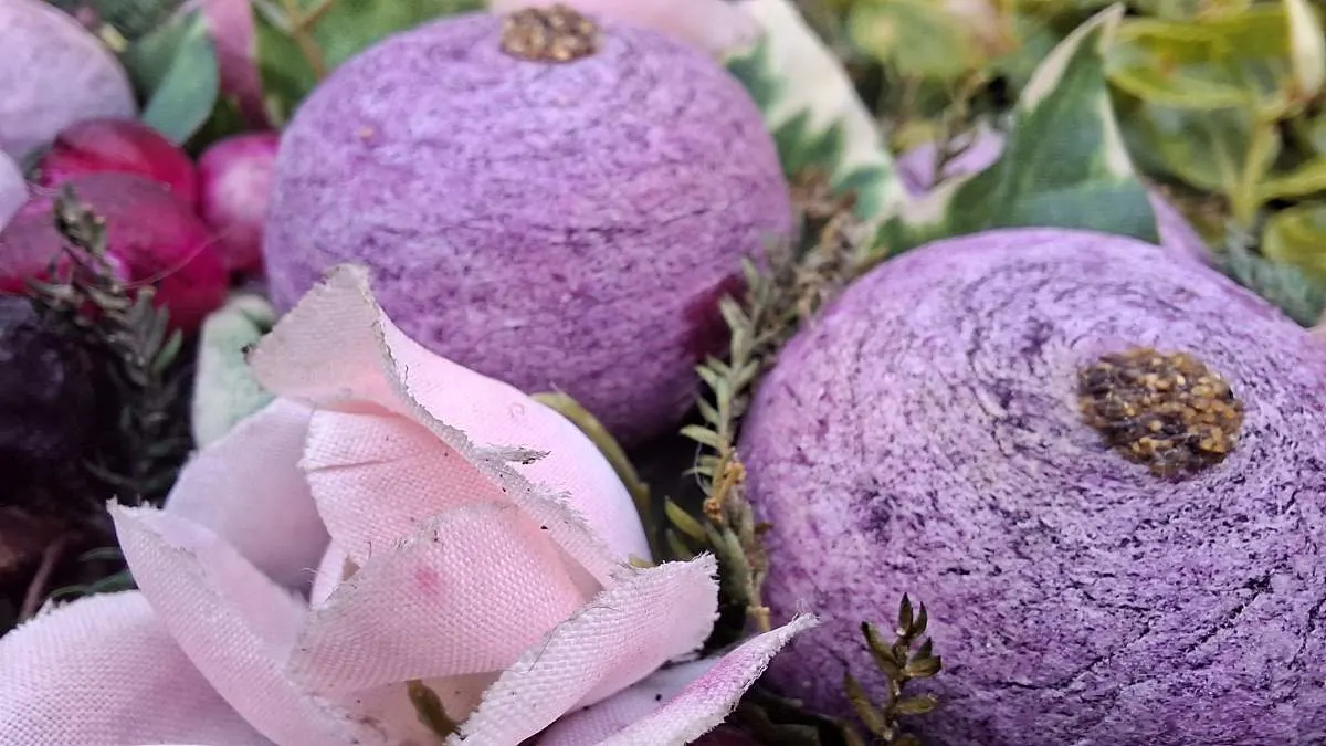 Eine Makroaufnahme von einer Plastikblume und Heidelbeeren, aufgenommen mit der Makrokamera des Samsung Galaxy A57.