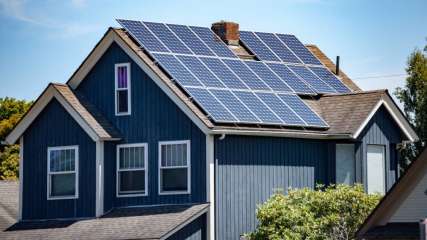 Eine Fotovoltaikanlage ist auf dem Dach eines Hauses angebracht.