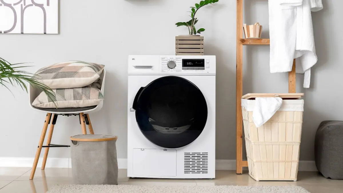 Der Wärmepumpentrockner OK. OTD 7342 steht mit geschlossener Tür in einem hellen Waschraum.