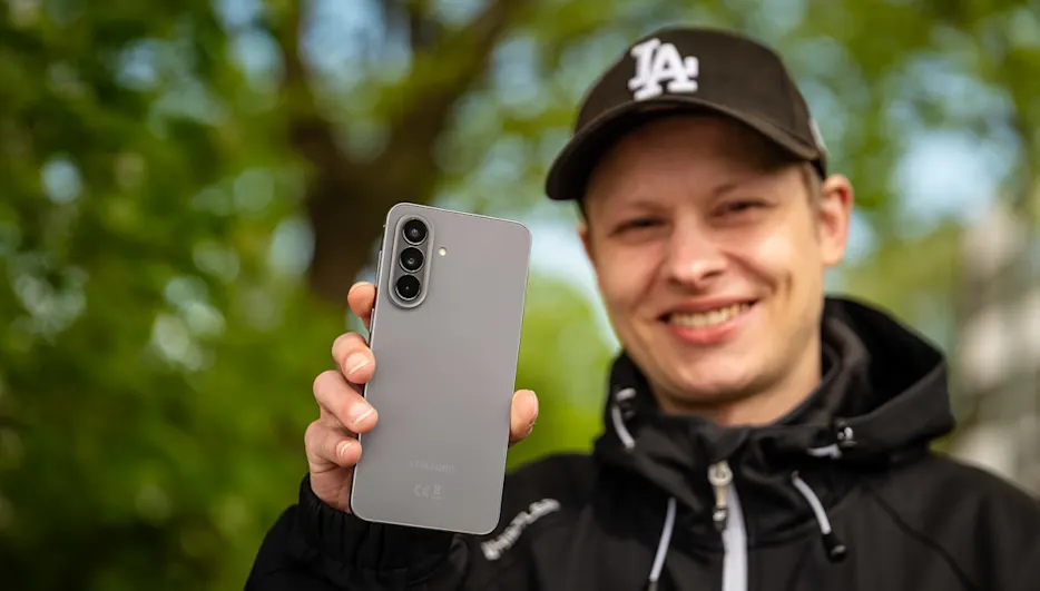 Alex hält das Samsung Galaxy A57 in die Kamera.