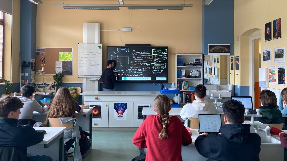 Blick in einen Klassenraum an der LIS mit Smartboard. Schüler nutzen Notebooks im Unterricht.