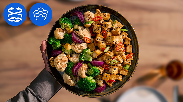 Ein Gericht mit Brokkoli. Blumenkohl und Tofu auf einem Teller angerichtet. Ein Steam und ein Airfry Logo sind in der Ecke abgebildet. 