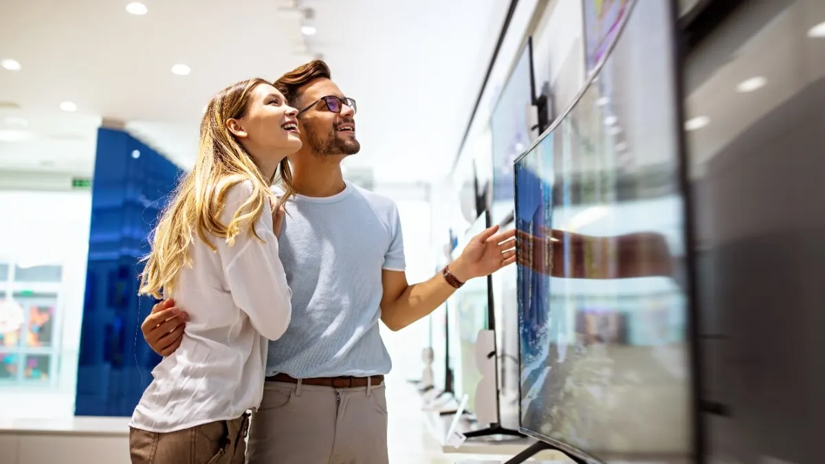 Eine Frau und ein Mann sehen sich im Fachhandel Fernseher an.