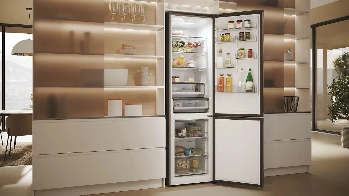 Die Kühl-Gefrierkombination Haier HDPW5620ANPD 2D 60 Serie 5 Pro steht mit geöffneten Türen in einer offenen Küche.