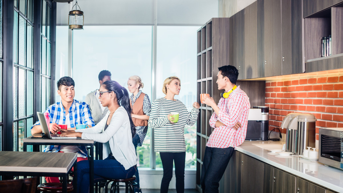 Eine Gruppe von Personen interagiert in einer Büroküche.