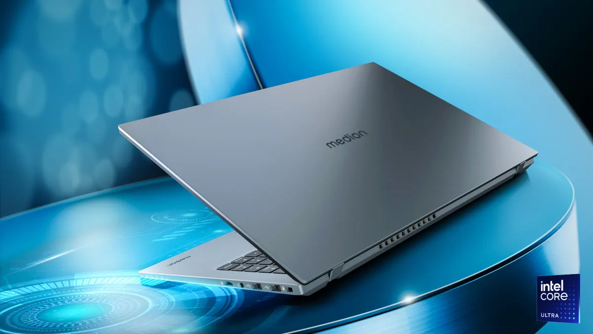 Ein grauer Medion-Laptop ist teilweise geöffnet auf einer blauen Oberfläche mit Intel Core Logo zu sehen.