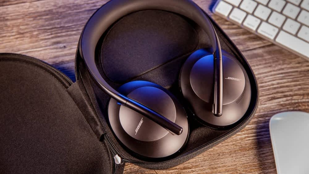 Die Bose Headphones 700 liegen in einer Tasche auf einem Schreibtisch.