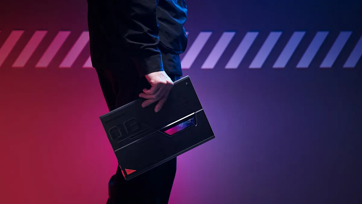 Eine Person hält einen schwarzen Laptop mit roten und blauen Akzenten vor einem rot-blauen Hintergrund mit weißen Streifen.