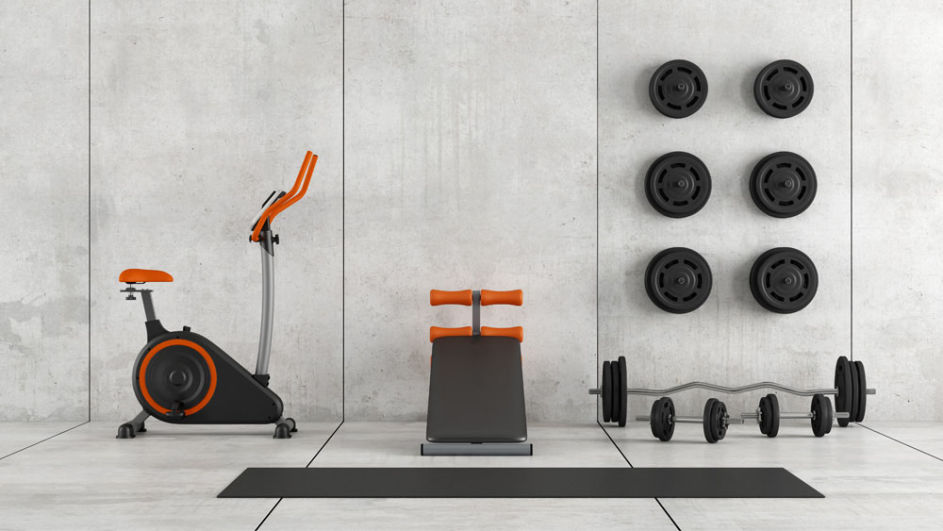 Ein moderner Raum ist mit Fitnessgeräten als Home-Gym eingerichtet.