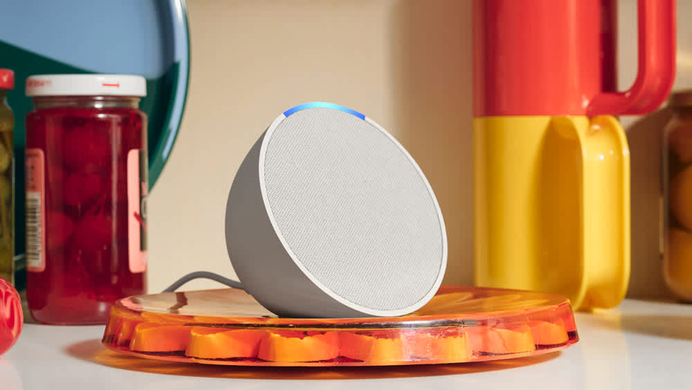 Der Amazon Echo Pop steht neben bunten Tassen und Einmachgläsern in der Küche.