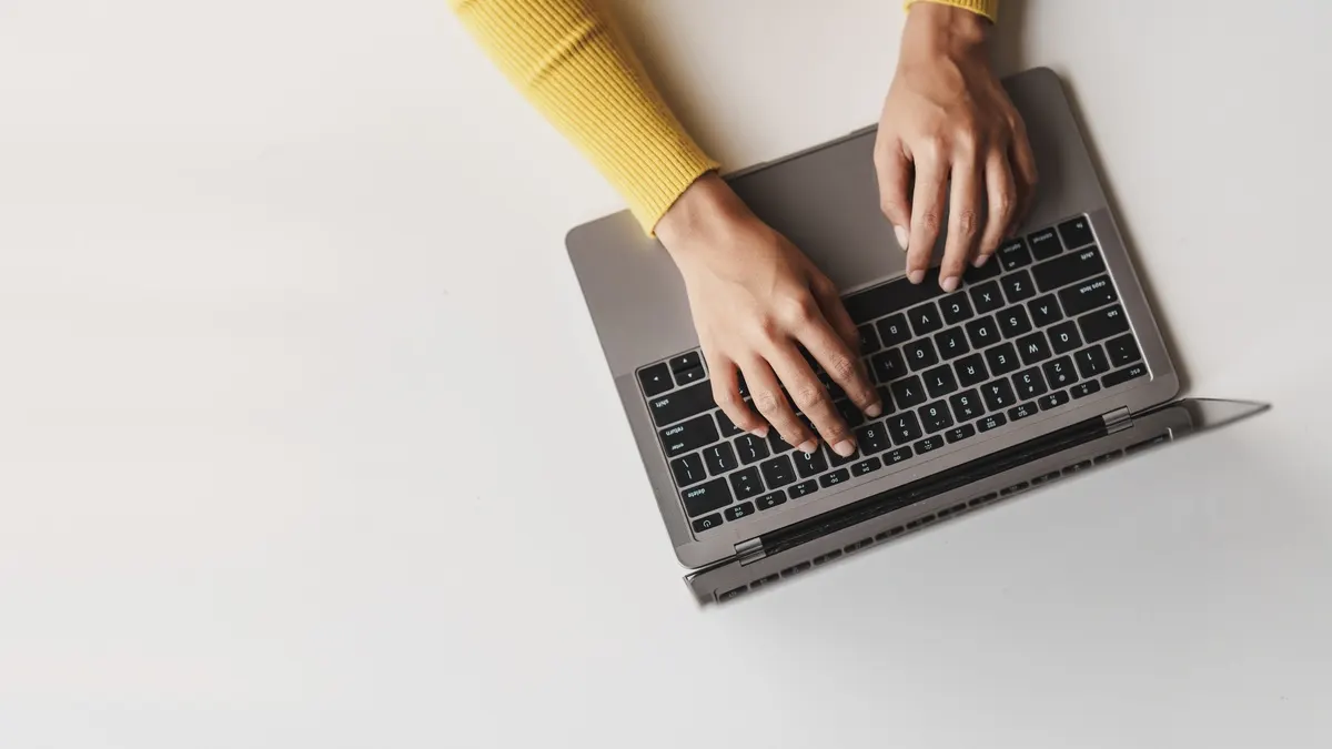 Eine Person tippt auf einer Laptop-Tastatur.