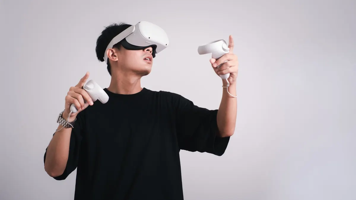 Ein Mann spielt mit einer VR-Brille und Controllern.