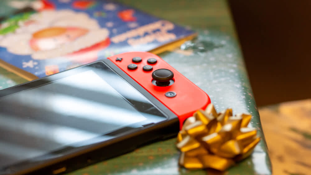 Eine Nintendo Switch liegt auf einem Geschenk.