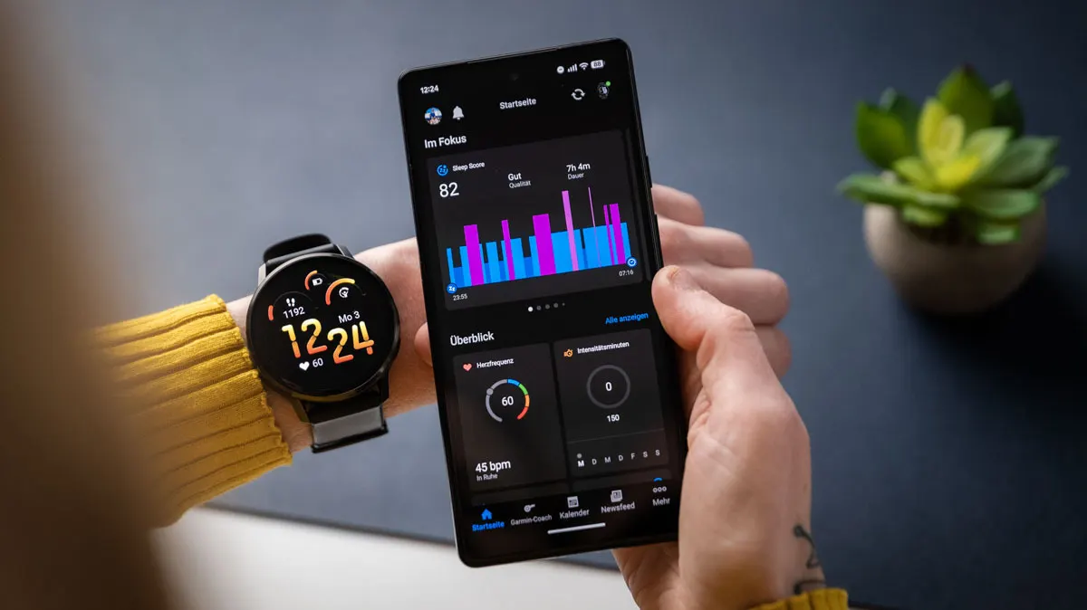 Franzi schaut sich die Schlafanalyse in der Connect-App auf dem Smartphone an, am linken Arm trägt sie die Garmin Venu 4.