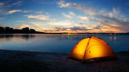 Zelt bei Sonnenuntergang am Wasser