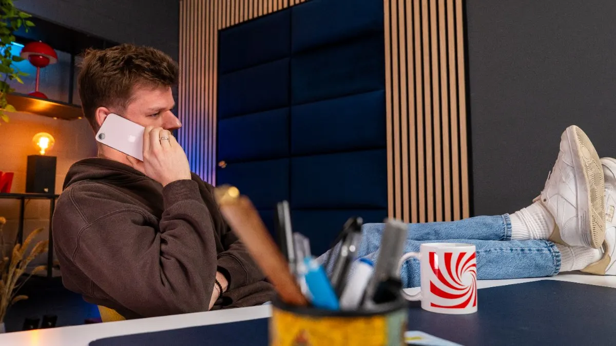 Niklas telefoniert mit dem iPhone 17e, während er die Füße auf den legt.