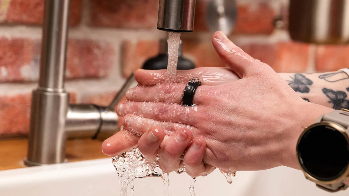 Franzi trägt den Ultrahuman Ring Air am linken Zeigefinger und wäscht sich die Hände.