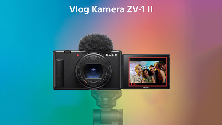 Eine schwarze Sony Vlog Kamera ZV-1 II mit Mikrofon und ausklappbarem Bildschirm vor einem bunten Hintergrund.