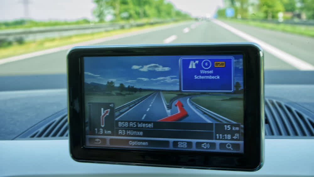 Ein Navigationsgerät hängt an der Scheibe eines Autos.