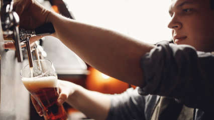 Ein Mann zapft Bier mit einer Bierzapfanlage.