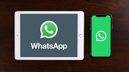 Ein iPad und iPhone mit WhatsApp Symbol liegen nebeneinander