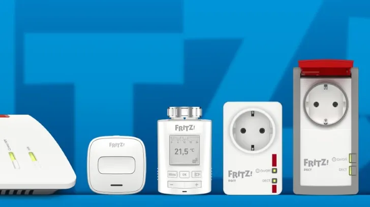 Weiße FRITZ!-Geräte, darunter Steckdosen, ein Thermostat und ein Router, stehen vor einem blauen Hintergrund.