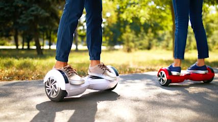 Zwei Personen auf einem Hoverboard im Park