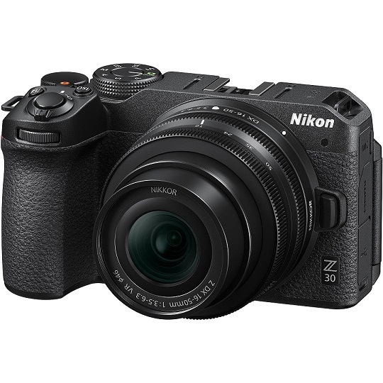 Eine schwarze Nikon Z 30 Kamera mit einem Nikkor Objektiv ist vor einem weißen Hintergrund zu sehen.