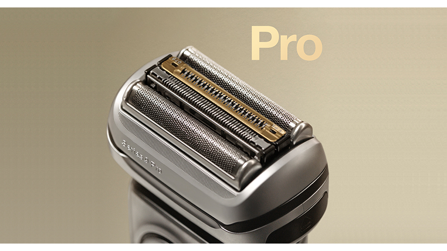 Nahaufnahme eines silbernen Rasierkopfes mit goldfarbenen Akzenten vor einem beigen Hintergrund und dem Wort "Pro".