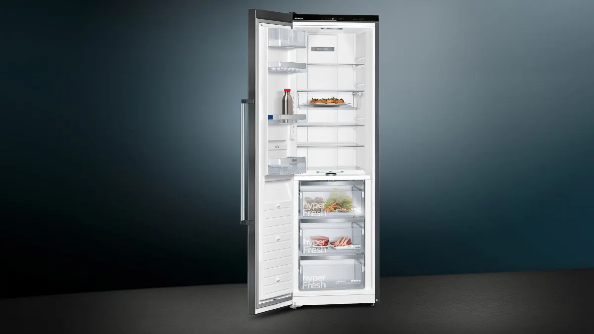 Der Kühlschrank Siemens KS36FPXCP iQ700 steht mit geöffneter Tür vor einem dunklen Hintergrund.
