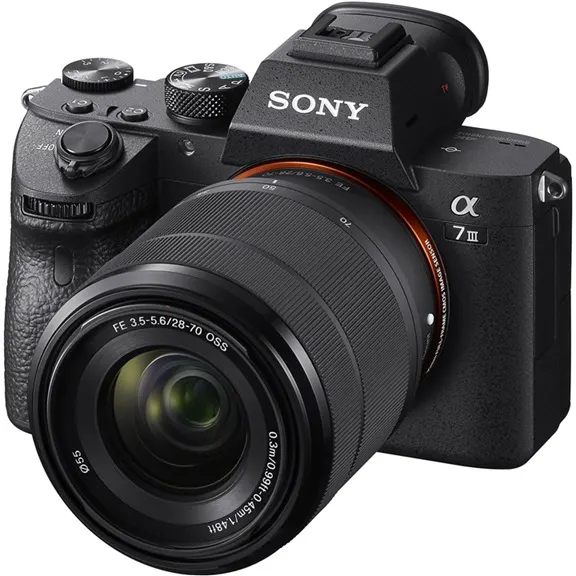 SONY Alpha 7 M3 KIT (ILCE-7M3K) + Tasche + Speicherkarte Systemkamera mit Objektiv 28-70 mm, 7,6 cm Display Touchscreen, WLAN Schrägansicht der spiegellosen Systemkamera SONY Alpha 7 M3 KIT (ILCE-7M3K) mit FE 28–70 mm Zoomobjektiv, Sucherbuckel und vielen Einstellrädern.