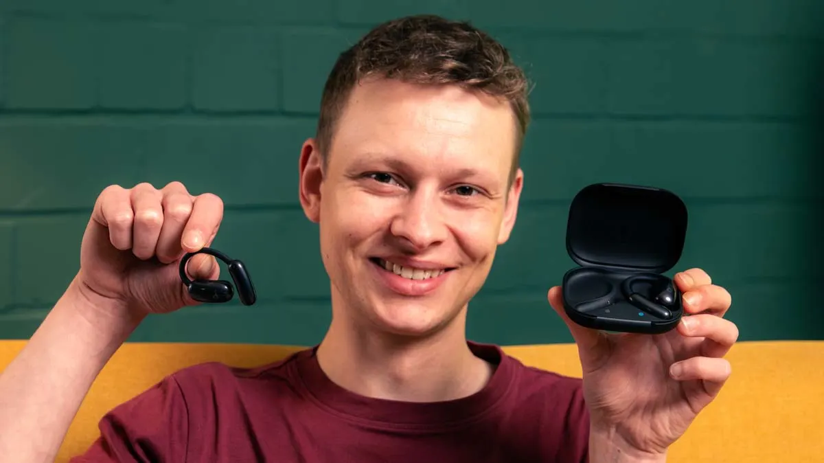 Alex zeigt einen Earbud der Open-Ear-Kopfhörer Soundcore Aerofit 2 und deren Ladecase in die Kamera.