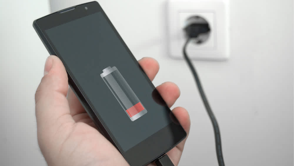 Ein Smartphone mit niedrigem Akkustand wird an einer Steckdose geladen.