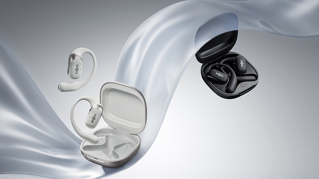 Drahtlose Kopfhörer in Weiß und Schwarz mit Ladeetuis auf einem grauen Tuch.