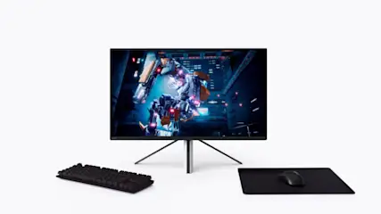 Ein Computermonitor zeigt ein Roboterspiel, mit einer Tastatur und einer Maus auf einem Schreibtisch.