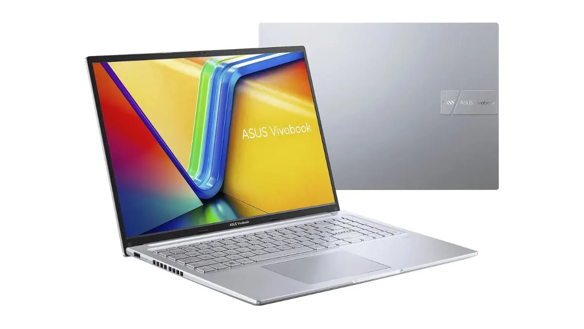 Ein silbernes ASUS Vivobook Laptop mit einem farbenfrohen Display steht vor einem silbernen Hintergrund.