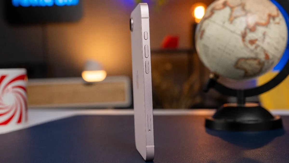 Das iPhone 17e steht hochkant auf einem Tisch und ist schräg von der Seite zu sehen.