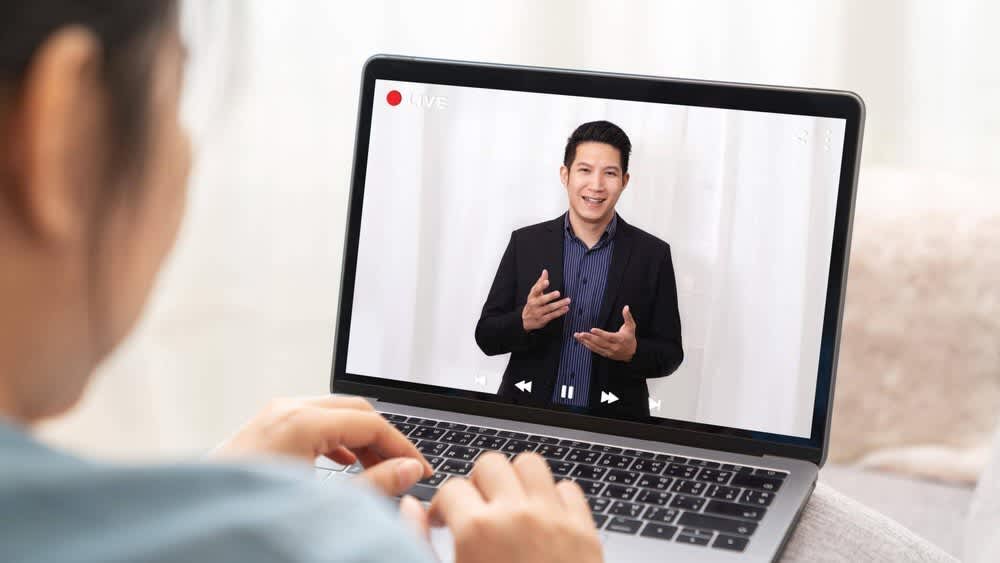 Eine Frau redet mit einem Mann via Videokonferenz über den Laptop
