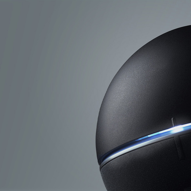 Schwarzes, abgerundetes Gerät mit blauem Lichtstreifen auf grauem Hintergrund.