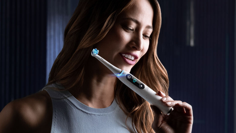 Frau mit elektrischer Zahnbürste von Oral-B 