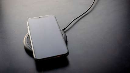 Ein iPhone liegt auf einem Induktionsladegerät.