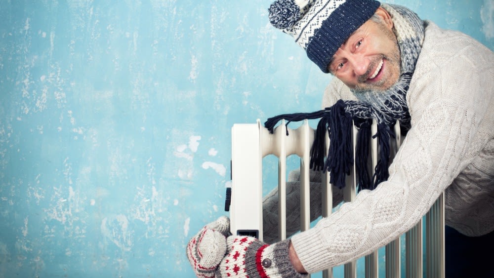 Mann umarmt Heizung im Winter