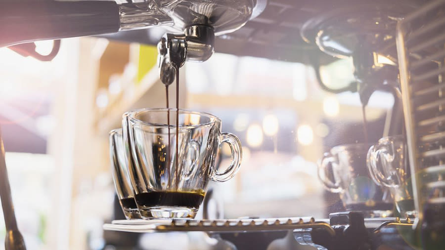 Aus einer Siebträgermaschine fließt Kaffee in zwei Tassen.