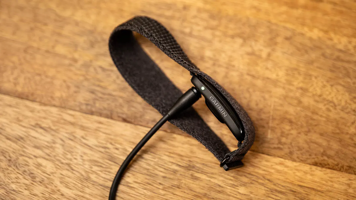 Das Garmin Cirqa liegt auf der Seite und lädt per Kabel.
