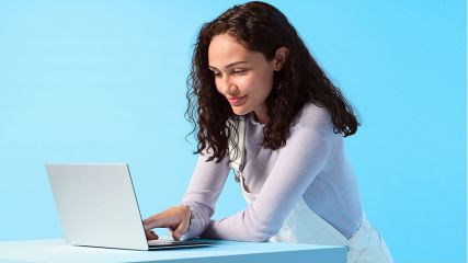 Eine Frau sitzt vor einem Laptop