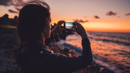 Handy-Bestenliste Frau mit Smartphone am Strand