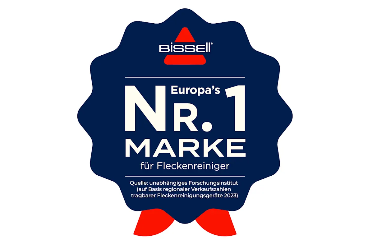 Dunkelblaues Abzeichen mit weißem Text "Bissell", "Europas Nr. 1 Marke für Fleckenreiniger" und rotem Dreieck-Logo.