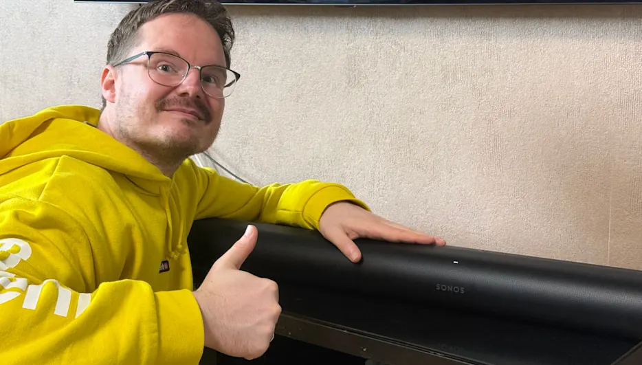Michael posiert mit einem Daumen nach oben vor der Soundbar Sonos Arc Ultra.