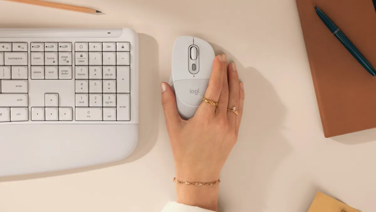 Eine Hand liegt auf einer Logitech-M850 L-Maus neben der MK880-Tastatur auf einem Schreibtisch.