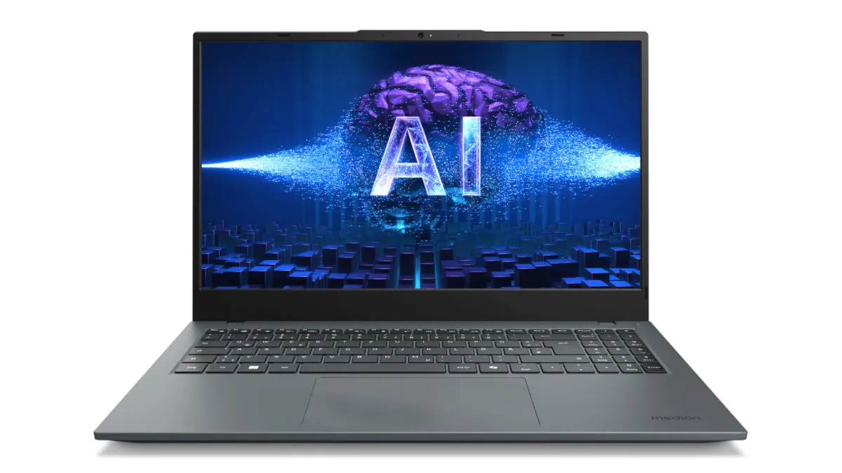 Ein grauer Laptop zeigt einen blauen Bildschirm mit der Aufschrift „KI“ und einem Gehirn vor einem Hintergrund aus blauen Würfeln.